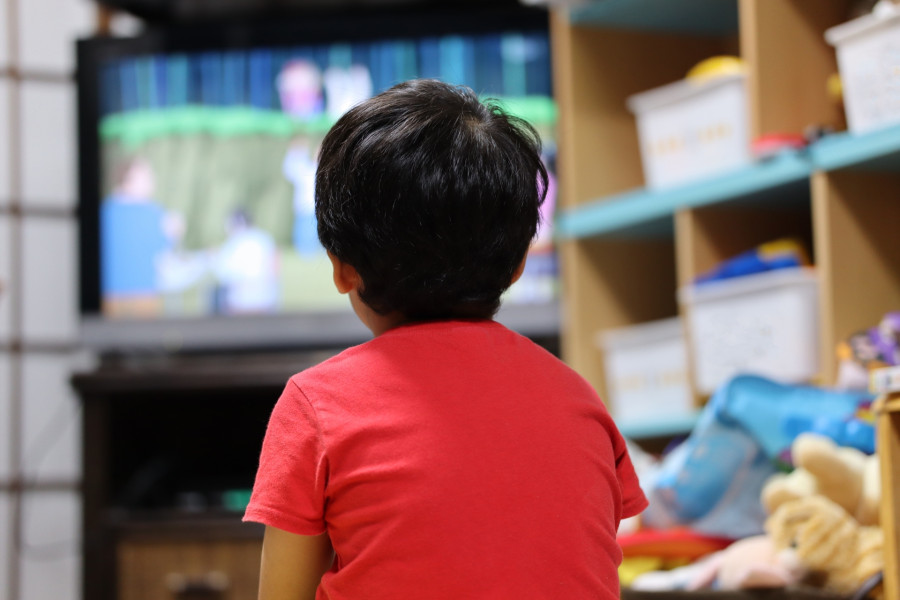 猫背でテレビを見ている子供