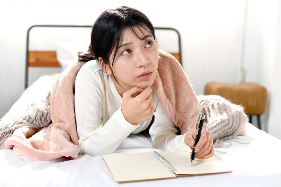 ベッドで勉強している女性